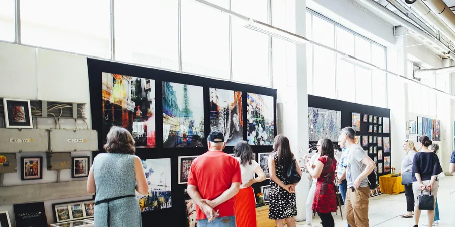 Visiteurs devant un stand de foire d’art