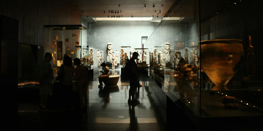 Musée en soirée Salle de musée éclairée en soirée avec visiteurs en silhouette