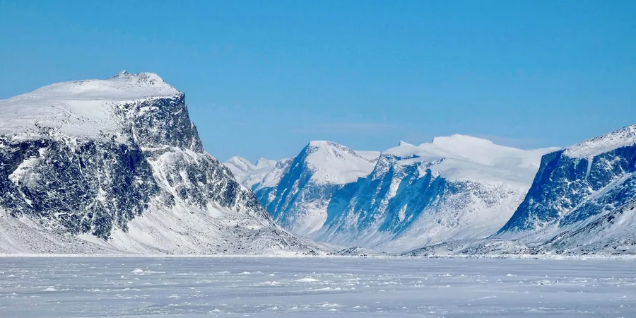 Paysage de l’Arctique canadien Fjord enneigé et montagnes de l’Arctique canadien sous la glace