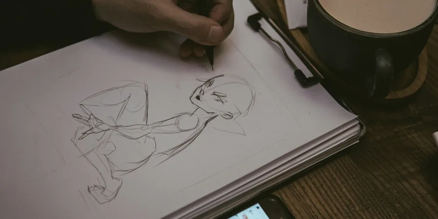Planche de bande dessinée en cours Main dessinant au crayon un personnage sur une feuille de papier