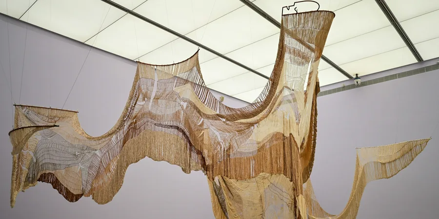 Grande sculpture en fibres suspendue au plafond d'une salle d'exposition