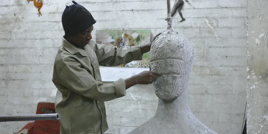Un sculpteur travaille sur un buste inachevé dans son atelier