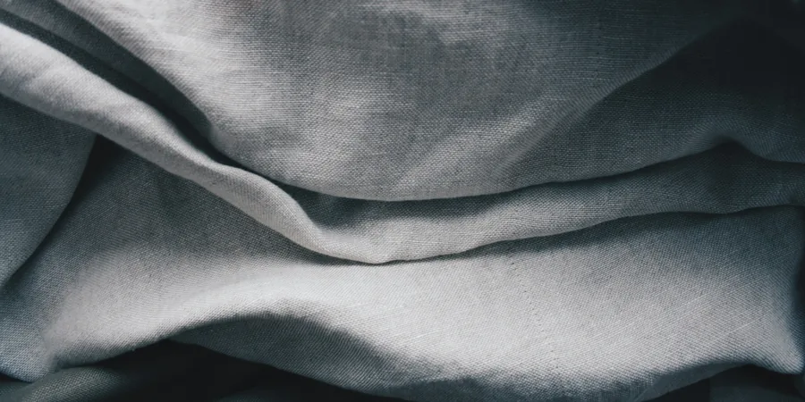 Plis d’un tissu drapé Plis souples d’un tissu de lin gris en gros plan